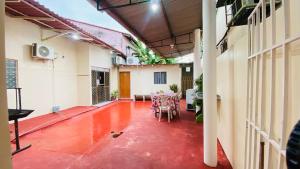 a room with a red floor and a table and chairs at Pousada Amiga in Parintins