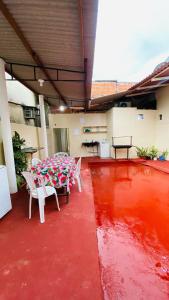 a patio with a table and chairs on a red floor at Pousada Amiga in Parintins