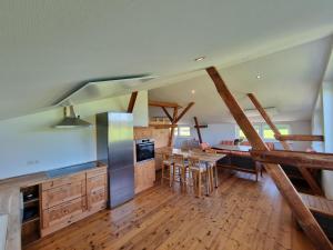 a large kitchen with wooden floors and a dining room at Pugholz XL in Hasselberg