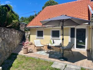 a patio with a table and chairs and an umbrella at Green House in Stara Sušica