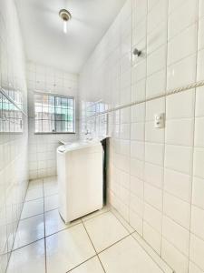 a white tiled bathroom with a sink in it at APARTAMENTO CONFORT NO CENTRO Ar cond 2 QUARTOS in Formosa +55 photos