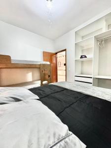 a bedroom with a large bed with a black blanket at APARTAMENTO CONFORT NO CENTRO Ar cond 2 QUARTOS in Formosa