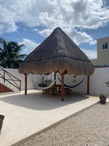 a hut with a hammock on a patio at Casa Loto A in Chelem