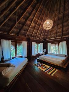 een slaapkamer met 2 bedden in een kamer met ramen bij Casa Mango in Tulum