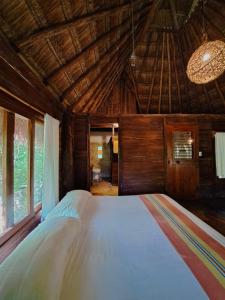 トゥルムにあるCasa Mangoの木製の天井のある部屋にある大きなベッド