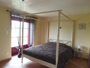 a bedroom with a canopy bed in a room at Gîte familial avec jardin clos à Falleron - FR-1-426-458 in Falleron