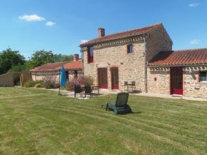 a chair sitting in the grass in front of a building at Gîte familial avec jardin clos à Falleron - FR-1-426-458 in Falleron