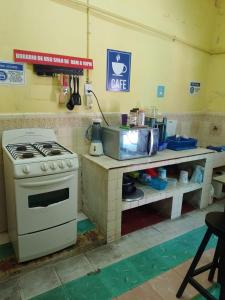 eine Küche mit einem Herd und einer Theke mit einer Mikrowelle in der Unterkunft Republic Hostal in Azcorra