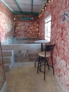 einen Tisch und einen Stuhl in einem Zimmer mit Ziegelwand in der Unterkunft Republic Hostal in Azcorra