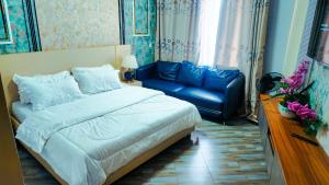 a bedroom with a bed and a blue couch at Vegas Suites and SPA in Kampala