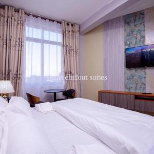 a bedroom with a large white bed and a window at Vegas Suites and SPA in Kampala