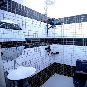 a black and white tiled bathroom with a sink at Vegas Suites and SPA in Kampala