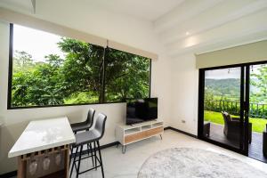 ビハグアにあるLa Danta Lodge - Celeste Riverのテレビとテーブルと椅子のあるリビングルーム +3枚の写真