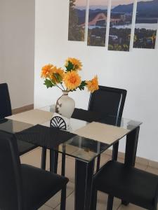 a dining room table with a vase with flowers in it at Alquiler de apartamento por días in Panama City