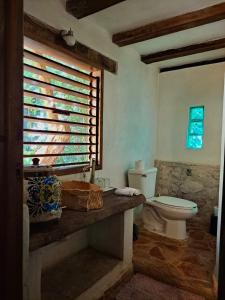 een badkamer met een toilet en een raam bij Casa Mango in Tulum