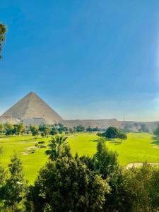 a view of the pyramids of giza and the trees at Moonlight golf view in Cairo +22 photos