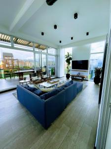 a large living room with a blue couch and a tv at Apartamento comodo cerca del aeropuerto in Estación Pamplona