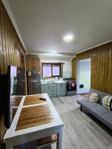 une cuisine et un salon avec une table et un canapé dans l'établissement Cabañas y Deptos Regional, à Valdivia