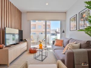 a living room with a couch and a tv at FLAMINGOS & SPA JACUZZi in San Pedro del Pinatar