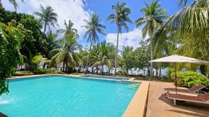 a pool at the resort with palm trees at Suki Beach Resort "3-3" Family Aircon Room in Sorsogon