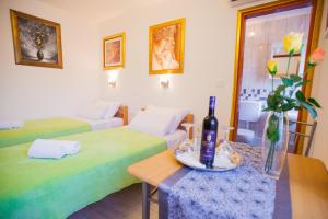 a room with two beds and a bottle of wine on a table at Golden Gate Dream Rooms in Split