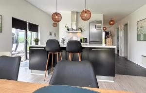 a kitchen with black and white counters and chairs at Holiday Home Pilemose Ii in Skovby