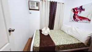 a small room with a bed with a bow on it at CK Condotel at Sanremo Oasis in Cebu City +8 photos