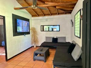 un salon avec un canapé et une télévision à écran plat dans l'établissement Casa Verano la rumbita Naturaleza, Piscina y Rio, à Santa Fe de Antioquia