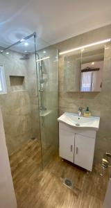 a bathroom with a sink and a glass shower at Πέτρινο σπίτι δίπλα στη θάλασσα in Votsalákia