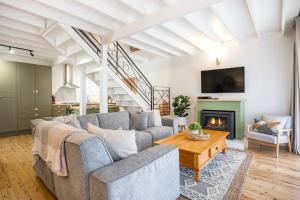 a living room with a couch and a fireplace at Wavesong on Watts - Pet Friendly with Spa in Callala Beach
