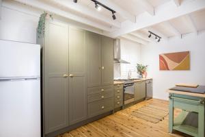 a kitchen with gray cabinets and a refrigerator at Wavesong on Watts - Pet Friendly with Spa in Callala Beach +30 photos