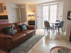 Una sala de estar con un sofá marrón y una mesa. en North Devon Luxe Gem for 4, 2 Ensuite Beds, Elegantly Renovated Sea Nearby, en Ilfracombe
