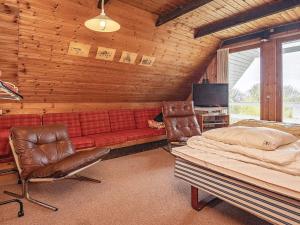 a bedroom with a couch and a bed and a tv at 10 person holiday home in Fur in Fur