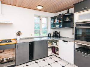 a kitchen with stainless steel appliances and a wooden ceiling at 12 person holiday home in Nordborg-By Traum in Nordborg