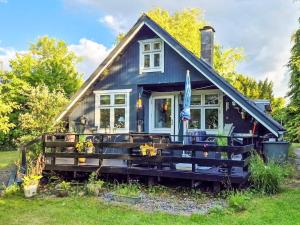 a small blue house with a porch at 4 person holiday home in Odder in Odder
