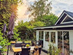オルダーにある4 person holiday home in Odderのテーブルと椅子が置かれた網戸付きの家のポーチ