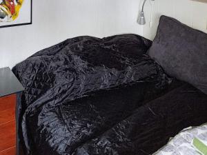 オルダーにある4 person holiday home in Odderのベッド(上に黒い毛布付)
