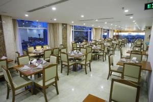 Un restaurante con mesas y sillas en una sala. en Glamour Hotel Nha Trang, en Nha Trang