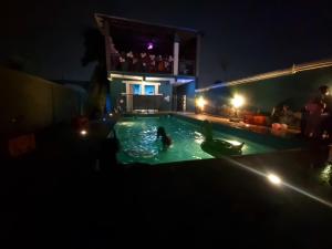 a group of people in a swimming pool at night at OSAK ROYAL GUEST House in Nsawam +5 photos