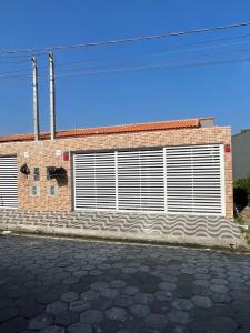 a brick building with two garage doors on it at Casa de praia com piscina, churrasqueira, com 2 vagas de garagem in Mongaguá