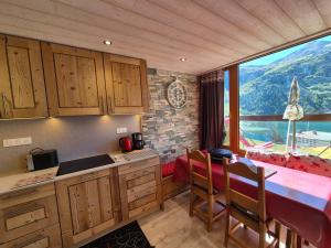 a kitchen with a table and a large window at Appartement rénové proche des pistes avec balcon - FR-1-502-389 in Tignes