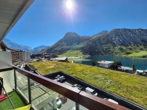 a balcony with a view of a lake and mountains at Appartement rénové proche des pistes avec balcon - FR-1-502-389 in Tignes