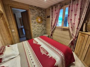 a bedroom with a bed with a red and white blanket at Appartement rénové proche des pistes avec balcon - FR-1-502-389 in Tignes