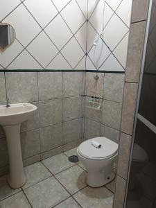 a bathroom with a toilet and a sink at Eventinho in Sao Jose do Rio Preto