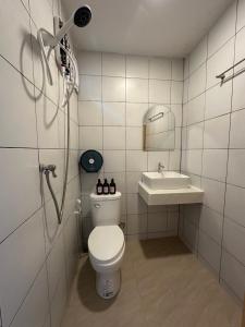 a bathroom with a toilet and a sink at ชิลล์ แคมป์ ชะอม in Ban Bung Mai