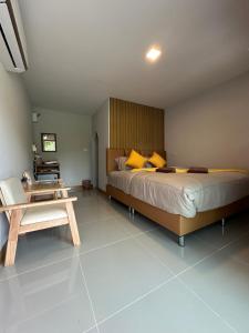 a bedroom with a large bed and a table at ชิลล์ แคมป์ ชะอม in Ban Bung Mai