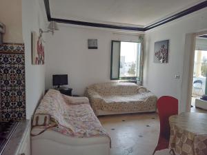 una sala de estar con dos camas y una mesa en Hammam sousse, en Hammam Sousse