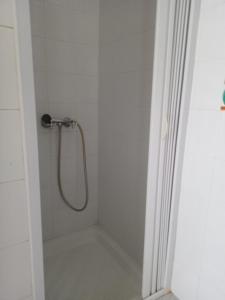 y baño blanco con ducha y manguera. en Hammam sousse, en Hammam Sousse