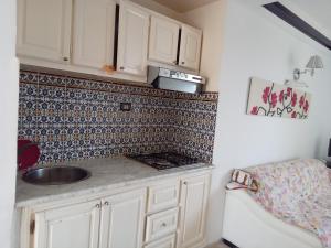 cocina con fregadero y salpicadura de azulejos en la espalda en Hammam sousse, en Hammam Sousse