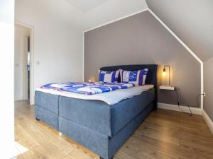 BuchholzReihenhaus mit WLAN in Buchholz am Müritzsee的一间卧室配有蓝色的床和蓝色枕头